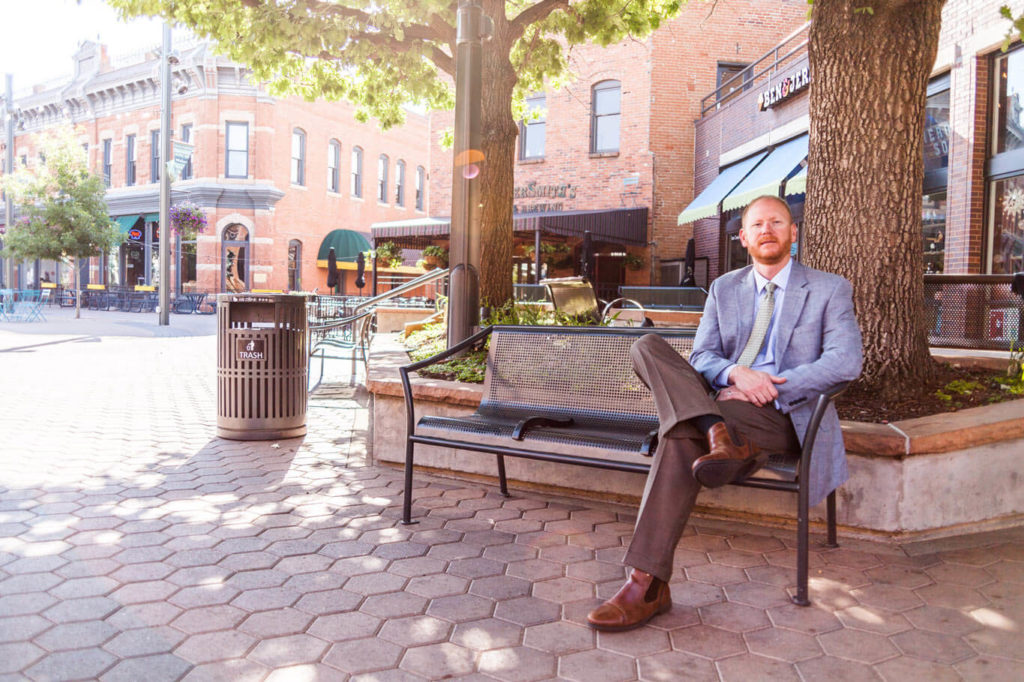 Stephen Doolittle Criminal Defense Attorney for Colorado sitting on a bench in Old Town Square, Fort Collins Colorado